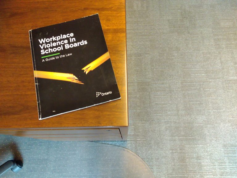MOL Workplace Violence in School boards document on a desk, cover shows a broken pencil